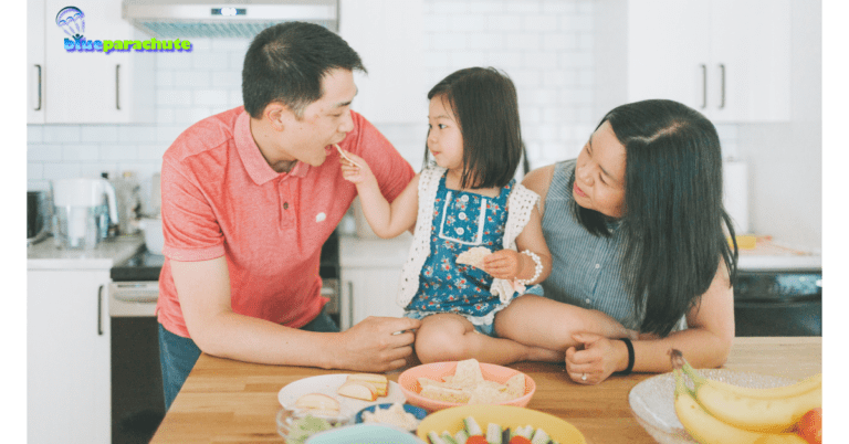 A man, woman, and their child are leaning on a kitchen counter as the child feeds the man. This implies that they are thinking about snack for an autistic child.