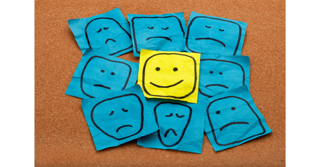 The blog discusses using positive reinforcement, and the image is a smiley face surrounded by sad or confused faces. This implies that positive reinforcement can help people.